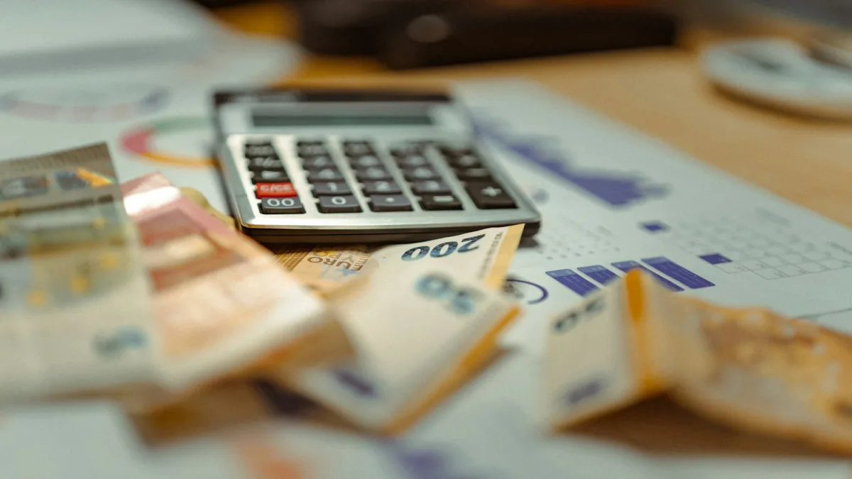 Kalkulator leżący na banknotach, symbol wyceny kosztów